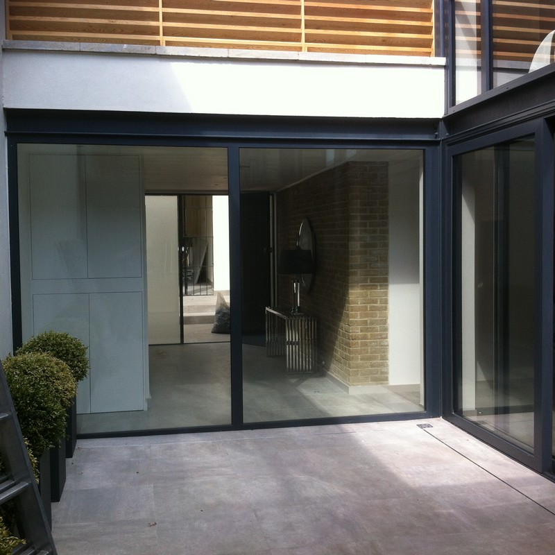 Floor-to-ceiling sliding doors opening to courtyard in Amersham